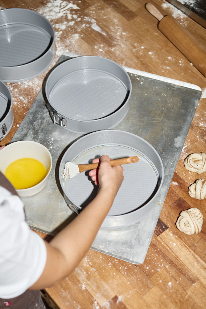 Damit der Kuchen während des Backvorgangs nicht an der Backform von Nordwik kleben bleibt, bepinselt Lilian sie mit einem Pinsel mit Butter.