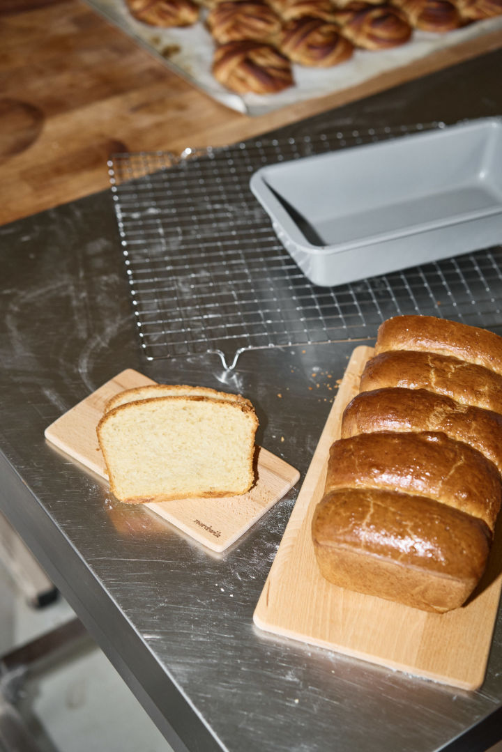 Hier sehen Sie ein aufgeschnittenes goldbraun gebackenes Briochebrot auf einem Holzbrett von Nordwik.